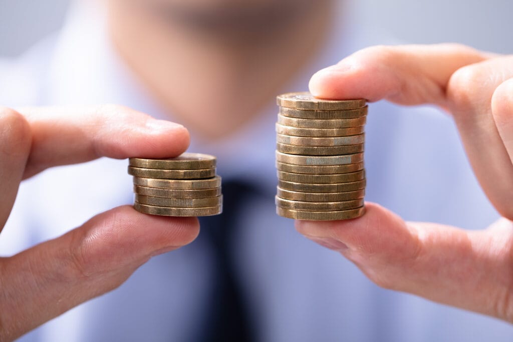 Person comparing unequal stacks of coins representing inheritance distribution and contested Will outcomes in Australia.